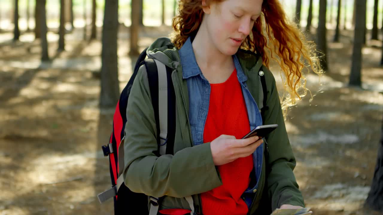 mujer usando teléfono móvil en el bosque 4k
