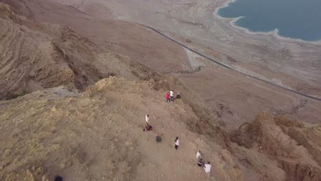 turista de pie en el borde del acantilado para ver el mar muerto en el medio oriente