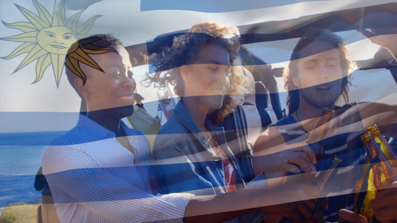 우루과이 국기 애니메이션을 배경으로 해변에서 술을 즐기는 친구들
