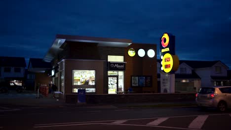 view of petrol station maxol, irish oil company and road with cars at night in dundalk , ireland