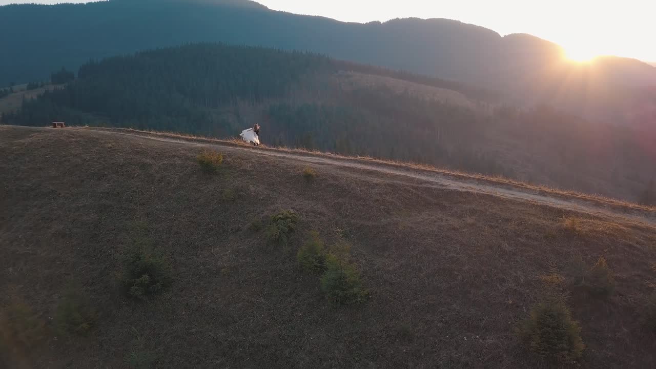 recién casados bailando en una alta ladera de la montaña. novio y novia. vista aérea
