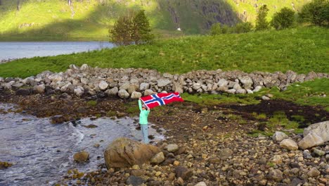 Frau-Mit-Einer-Wehenden-Norwegischen-Flagge-Auf-Dem-Hintergrund-Der-Natur