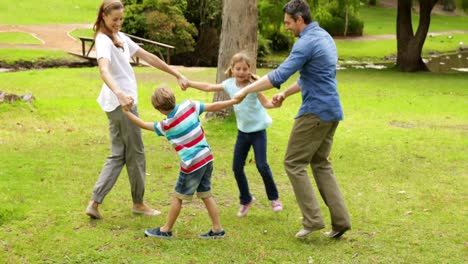 Familia-Feliz-Jugando-Juntos-Al-Ring-A-Rosie-En-El-Parque