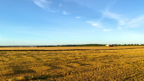 golden fields with farmers working tractors and combine harvesters in slow motion - high frame rate