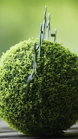 hands around a green globe. paper figures hold hands around a moss-covered globe symbolizing unity and environmental awareness in nature.