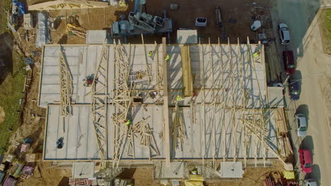 vista aérea de los trabajadores que trabajan en el sitio de construcción, vigas de madera del edificio