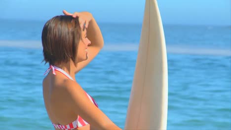 Mujer-Atractiva-Posando-Con-Una-Tabla-De-Surf