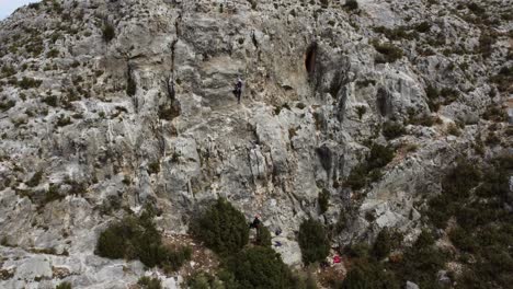 Female-rock-climber-in-a-stone-wall-in-the-countryside