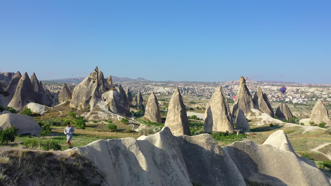 viajero masculino caminando hacia el perro en el paisaje de capadocia, antena hacia atrás