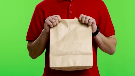mensajero sosteniendo una bolsa de papel artesanal reciclable con pedido de alimentos