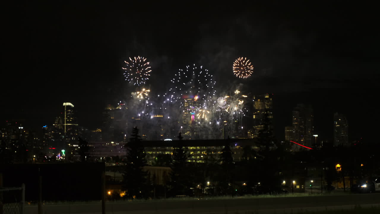 brillantes fuegos artificiales caprichosos explotan en el cielo nocturno sobre el horizonte de la ciudad