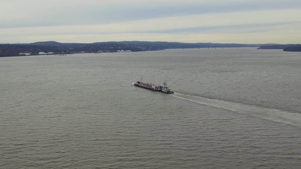 imágenes aéreas siguiendo a un buque de carga sobre una gran masa de agua