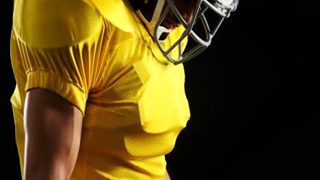 american football player standing against black background 4k