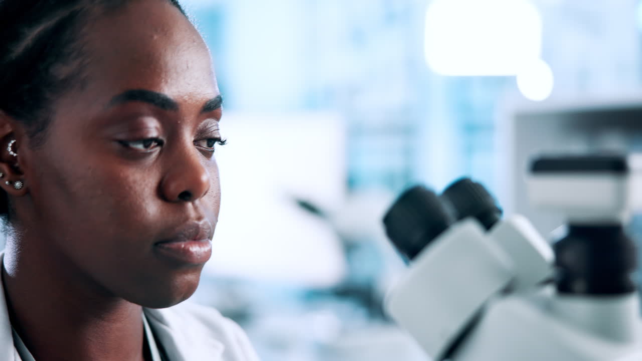 Scientist examining sample under microscope