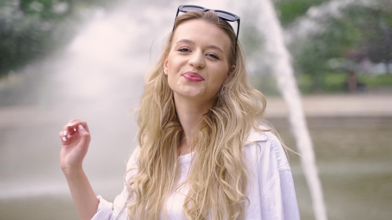 분수 근처 에 있는 공원 에서 미소 짓는 여자