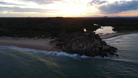 aerial rising over elephant rock during colorful sunset in popular surfing destination of arugam bay, sri lanka.