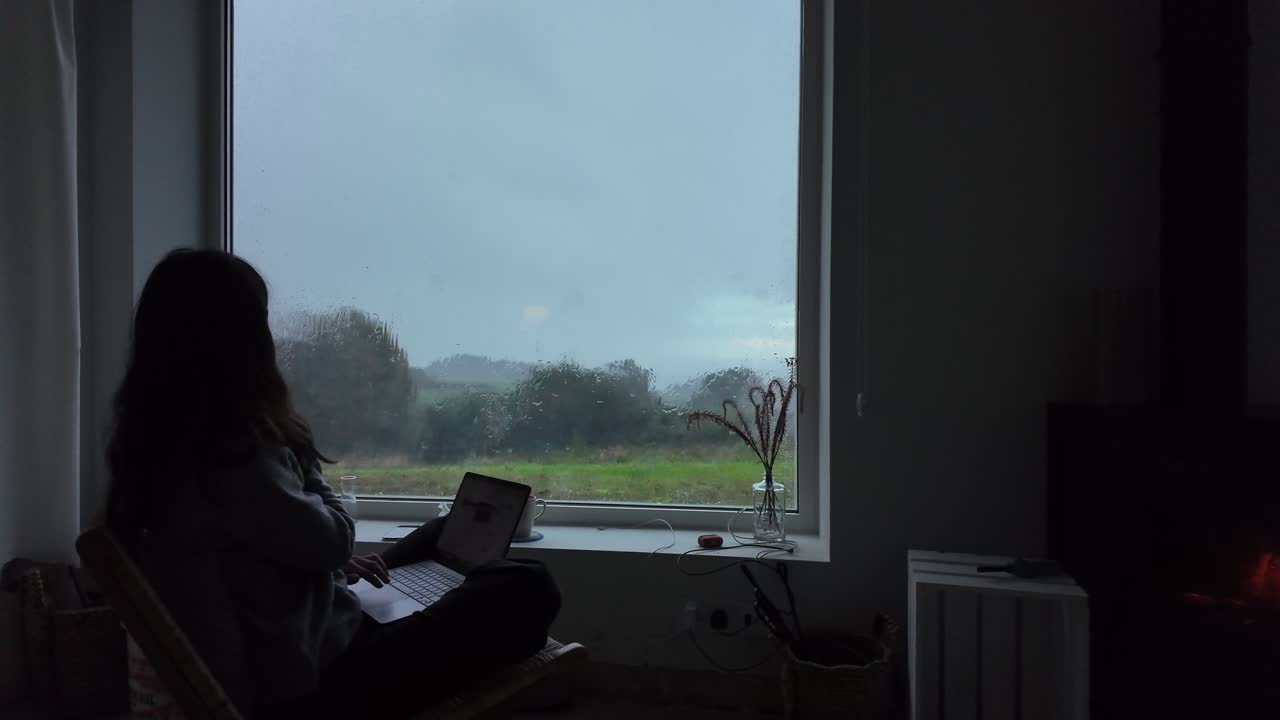 Mujer a cámara lenta trabajando de forma remota en un portátil en un entorno rural