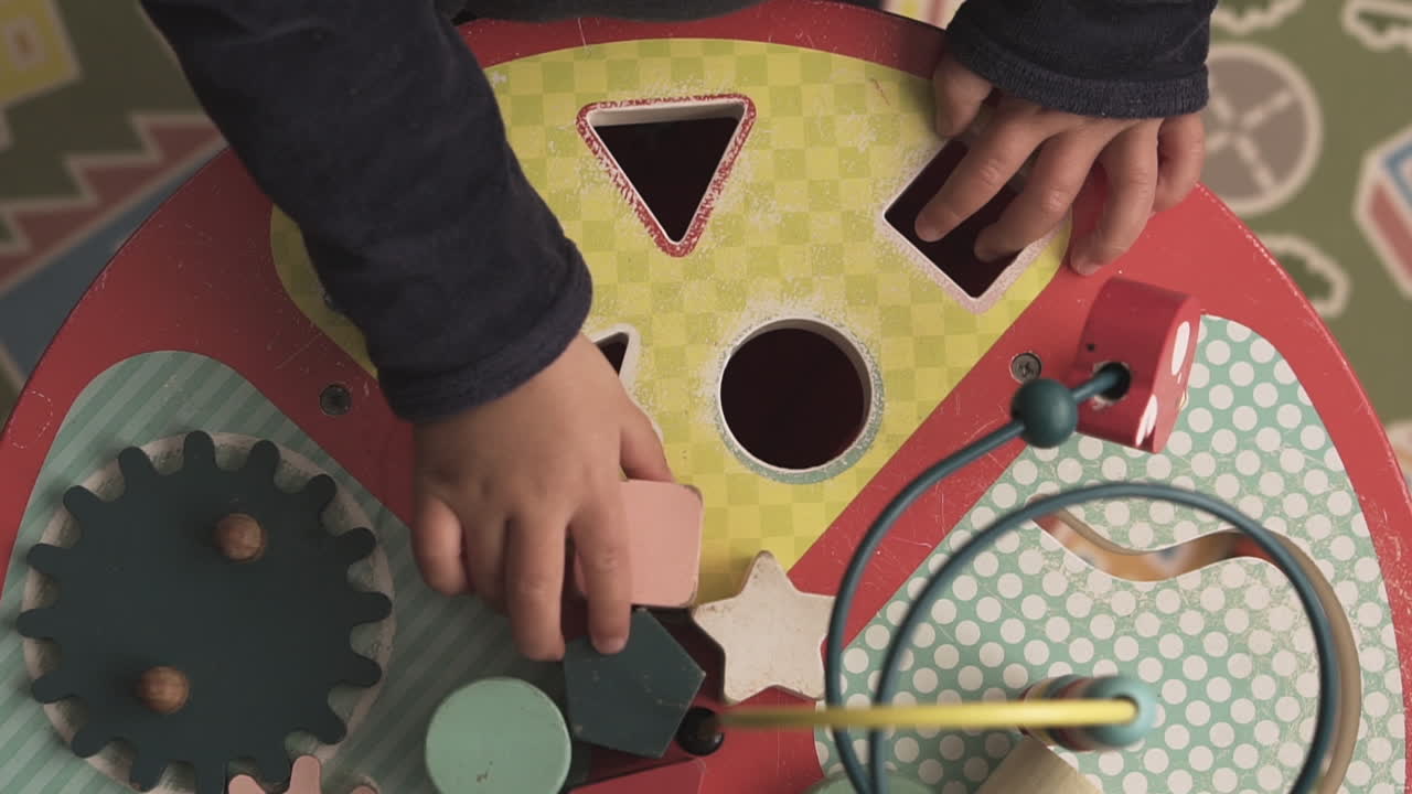 모양 과 조각 을 테이블 에 맞추지 못하는 아기 의 위쪽 시상