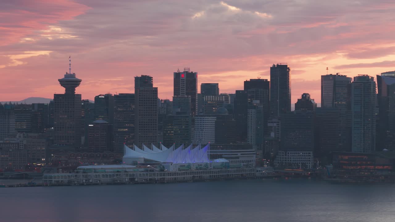 Telephoto dolly aerial shot of Canada Place in downtown Vancouver as seen from the north shore during golden hour in British Columbia, Canada. 4K