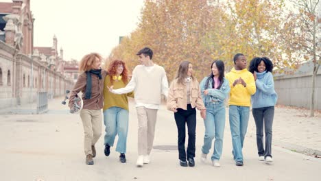 multi-ethnic friends chatting and walking relaxed in the city