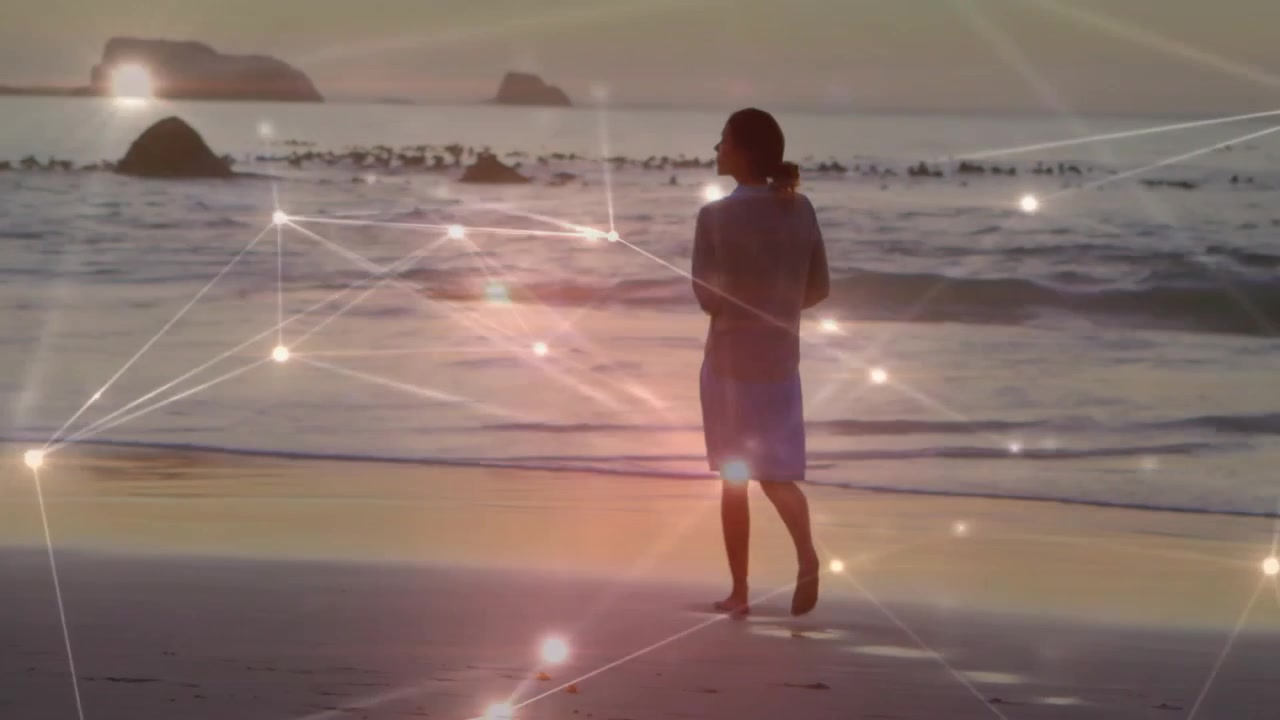 Donna che solleva il tallone avviando una sovrapposizione di griglia tecnologica mentre cammina sulla sabbia bagnata, guardando l'oceano.