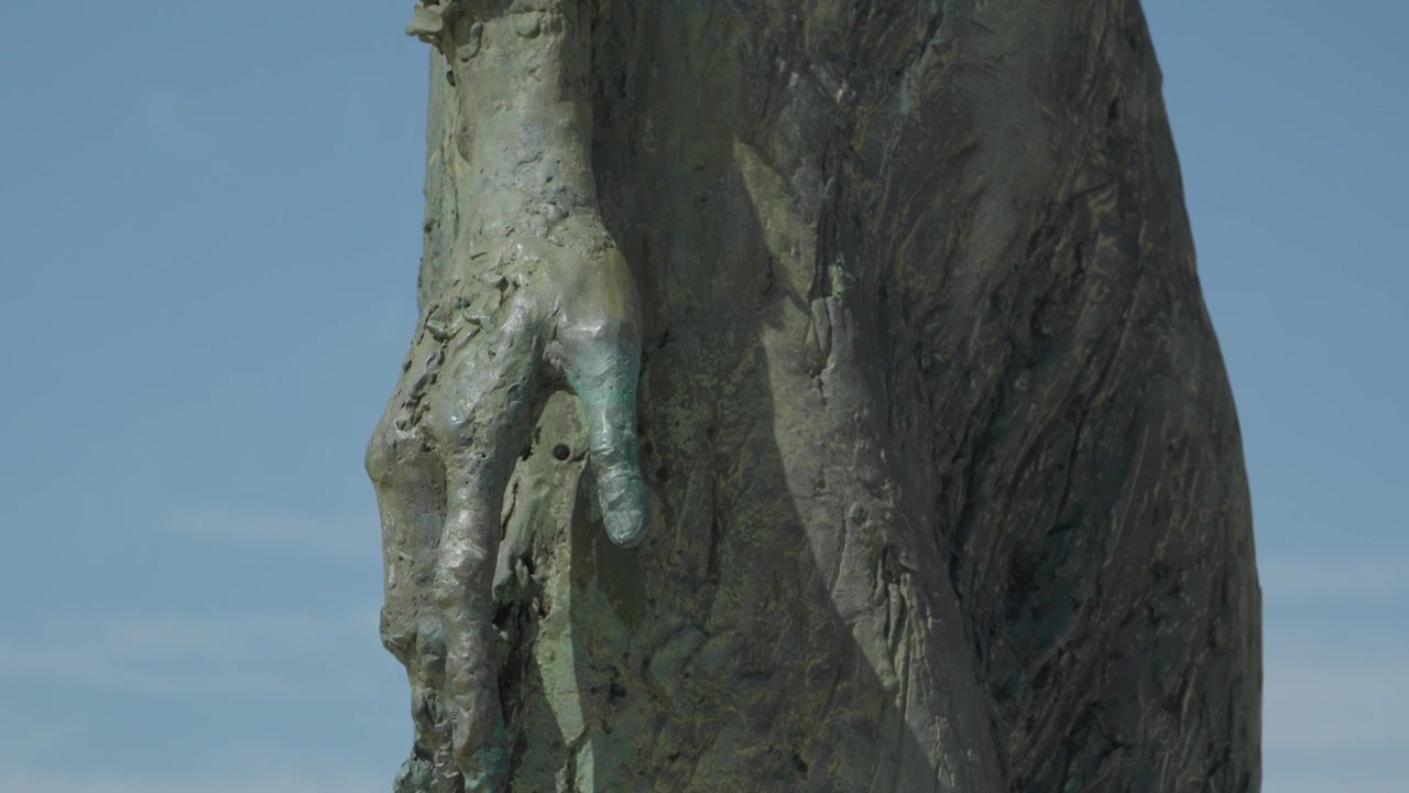 Nærbillede af detalje af bronze venstre hånd på Monument til Indvandrernes Moder-statuen i Gijón, Spanien.