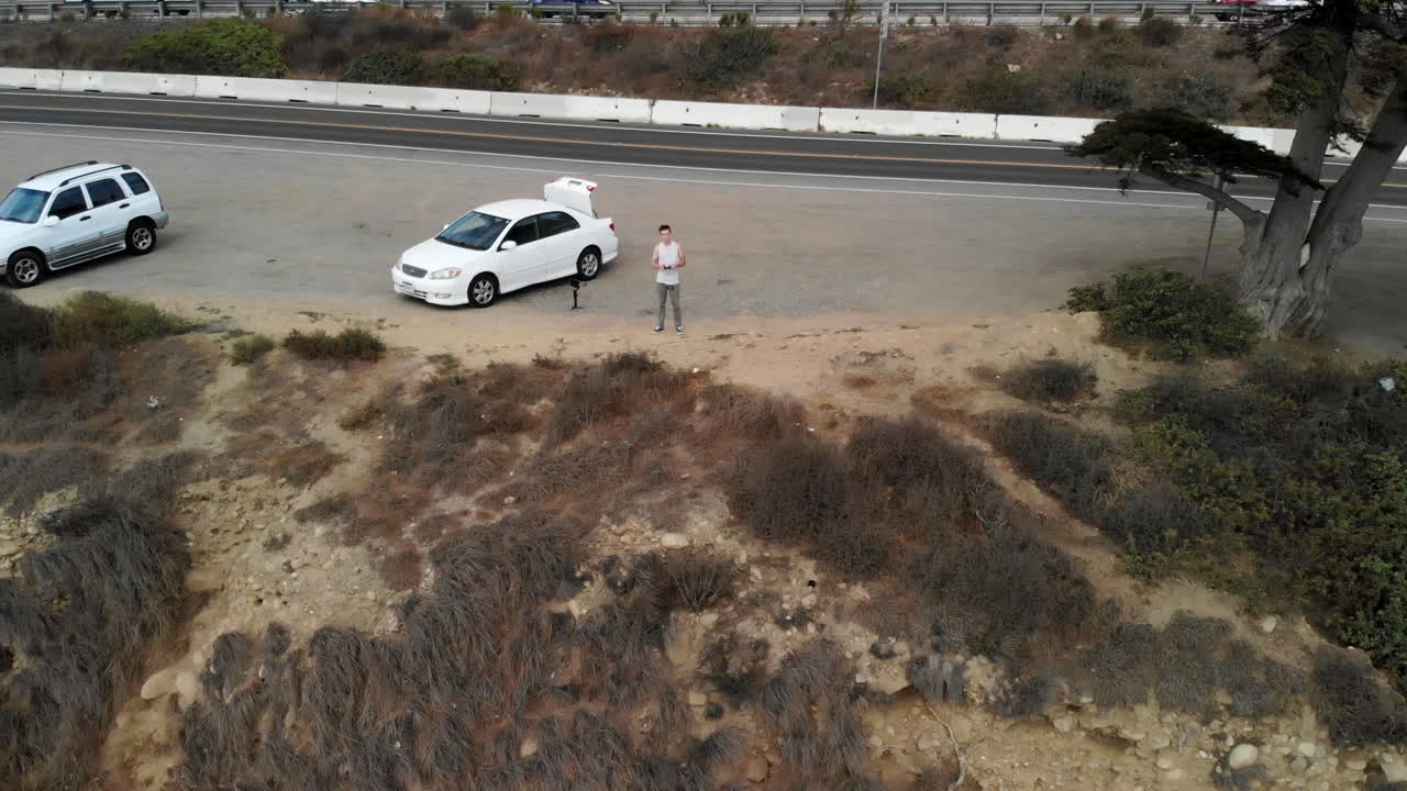 젊은 백인 무인기 조종사로부터 캘리포니아 벤추라 해안에서 떨어진 푸른 태평양으로 뒤로 당기는 공중 샷