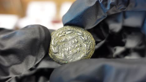 collector examining ancient provincial roman coin