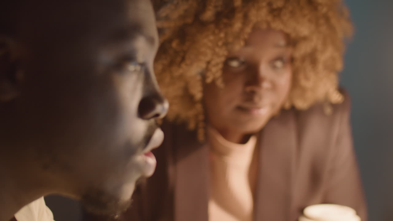 African American Coworkers Talking in Office in Evening