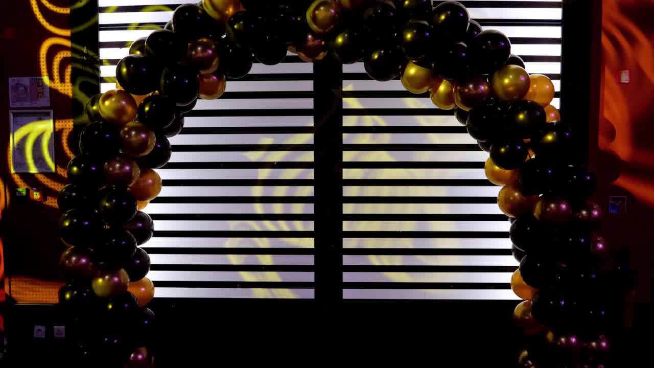 360 degree rotation of a large black and gold balloon, during a gala evening, which allows you to take a photo