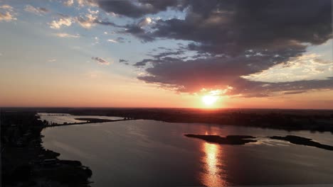 Descending-on-a-golden-sunrise-reflecting-on-Moses-Lake,-Washington,-aerial