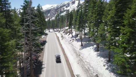 Tracking-shot-following-behind-truck-as-it-drives-along-a-mountain-road-through-the-forest