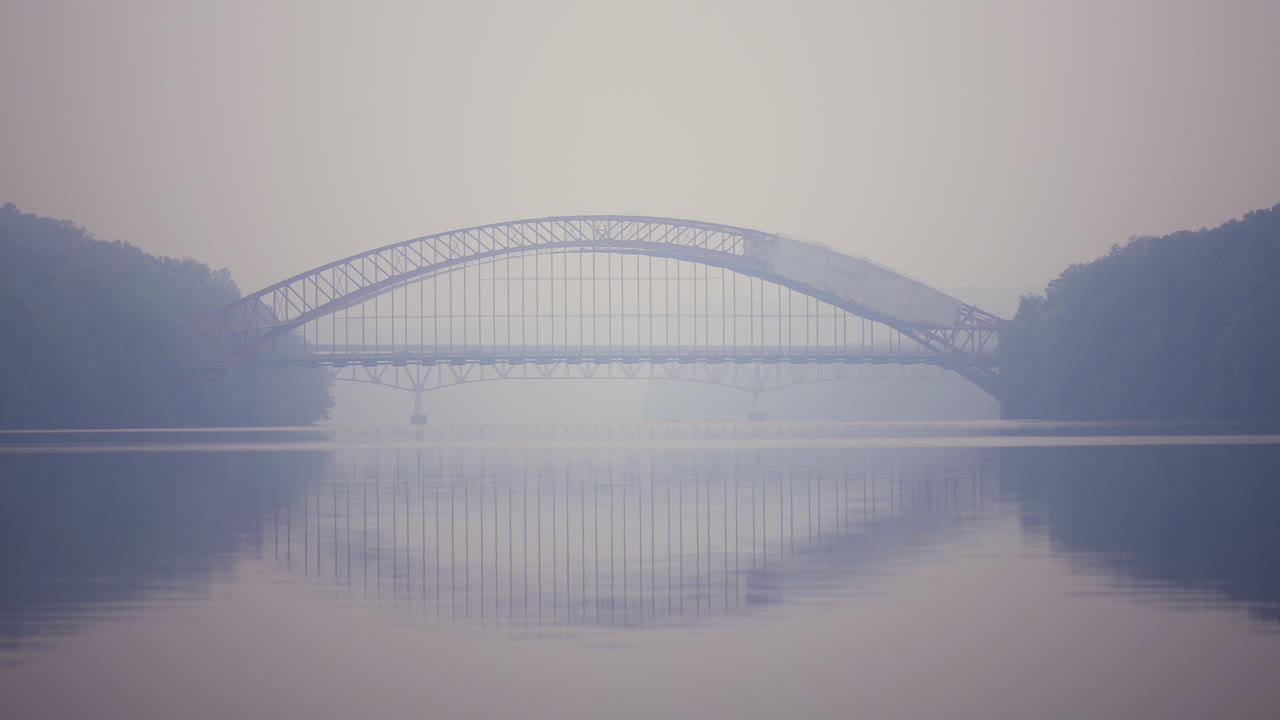An ambulance speeds across a bridge on a day with heavy smoke pollution
