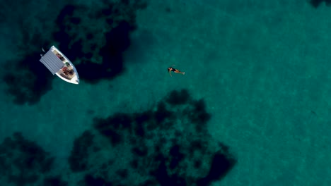 Young-Woman-Floating-on-Truquoise-Waters-in-Summer-Holidays,-Greece