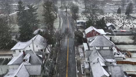 Inclinación-Aérea-Revela-Tormenta-De-Nieve-Sobre-El-Barrio-Y-El-Cementerio-Americano