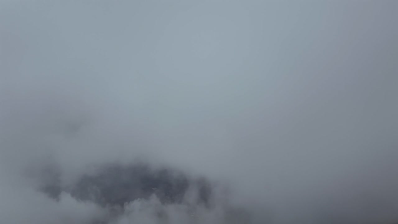 A Pilot’s view taken from a jet airplane cockpit flying through fluffy stratus clouds under a deep blue sky. Ultra-realistic4K shot