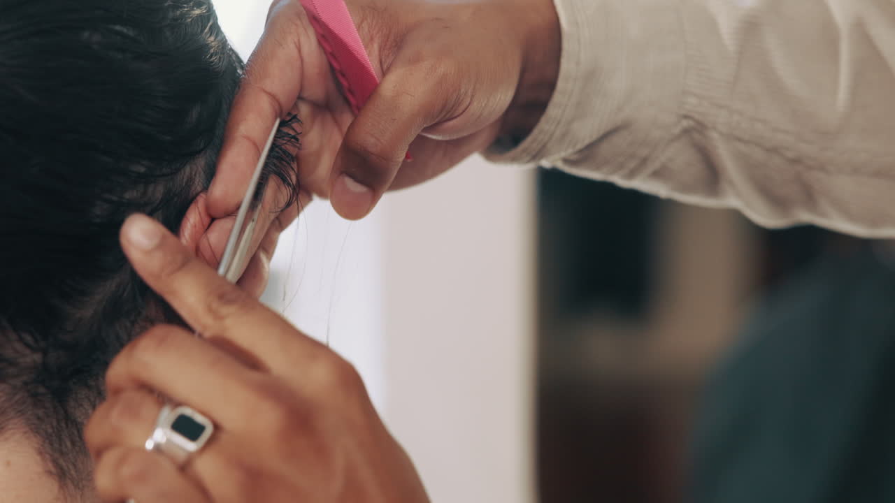 Close Up of Barber Trimming Hair with Scissors and Comb