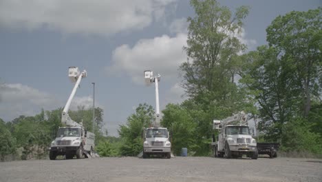 three trucks are parked next to each other on a gravel parking lot