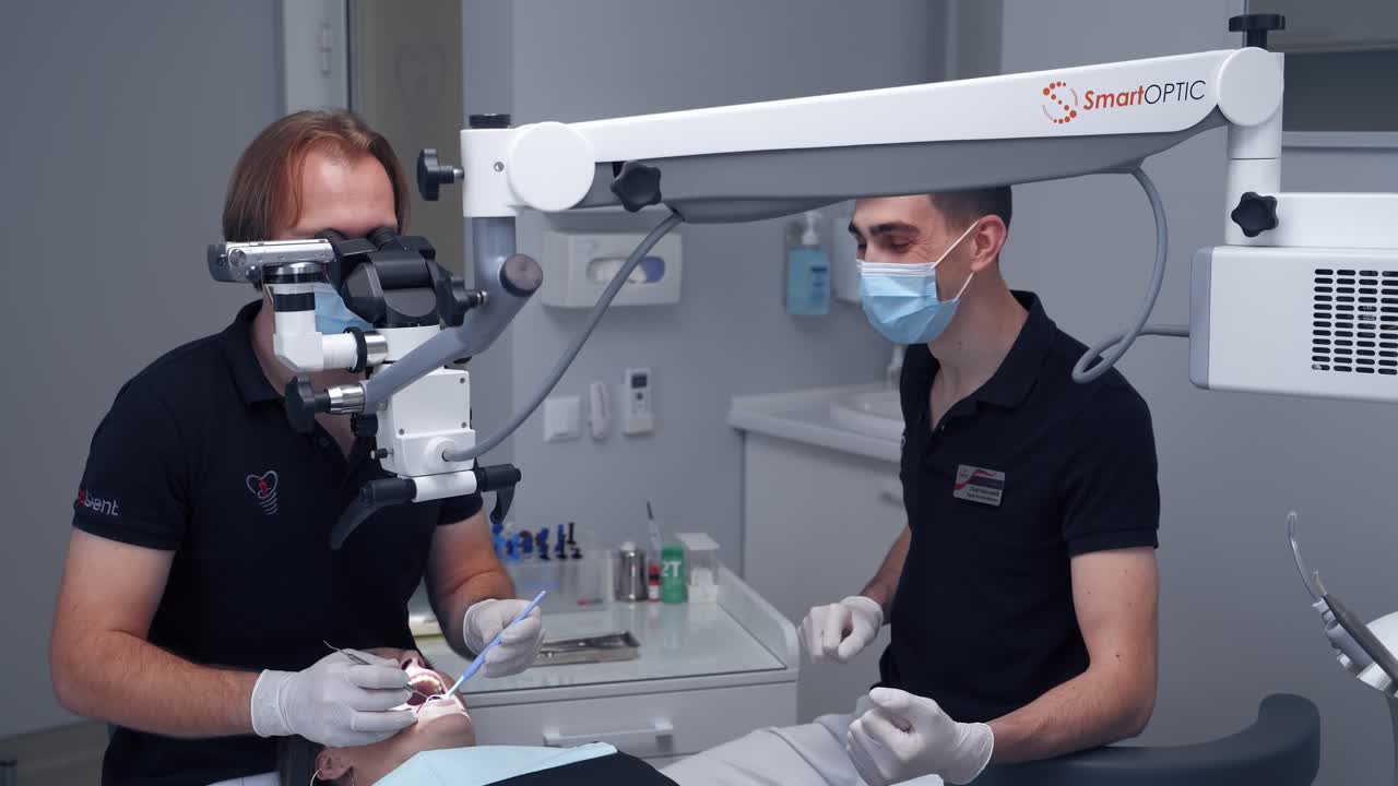 Stomatologist uses modern medical equipment. Professional dentist treats patient's teeth through the microscope. Dental treatment concept.
