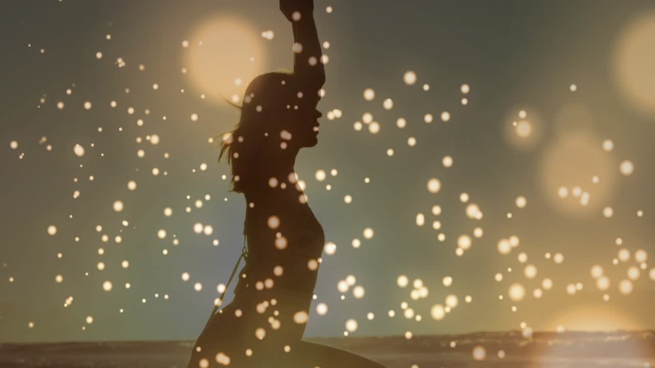 Woman stepping into lunge on wet sand for yoga, engaging core raising arms as particles drift