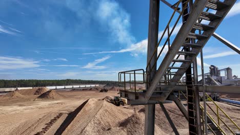 fotografía amplia de un cargador delantero en una planta de procesamiento de pellets de madera