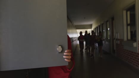 boy opening his locker in the school