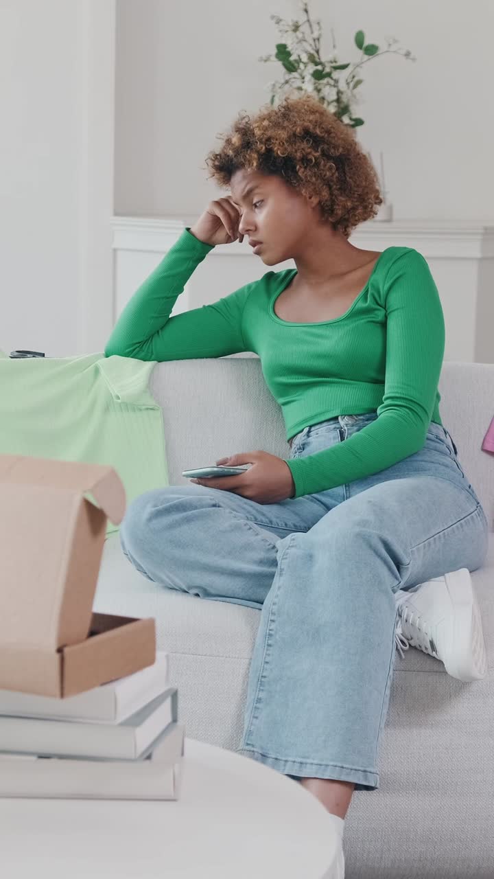Young woman in green top relaxes while scrolling on her phone at home
