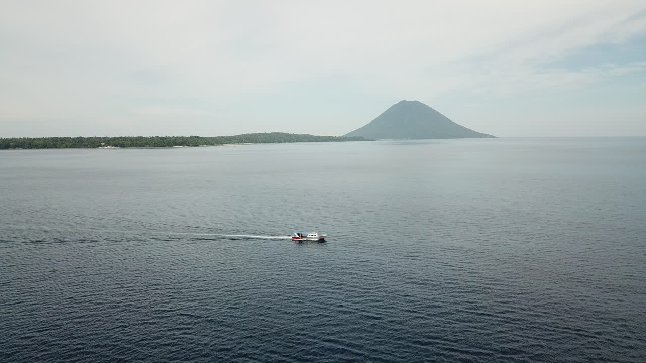 Barco Navegando no Oceano em Direção a uma Ilha Vulcânica