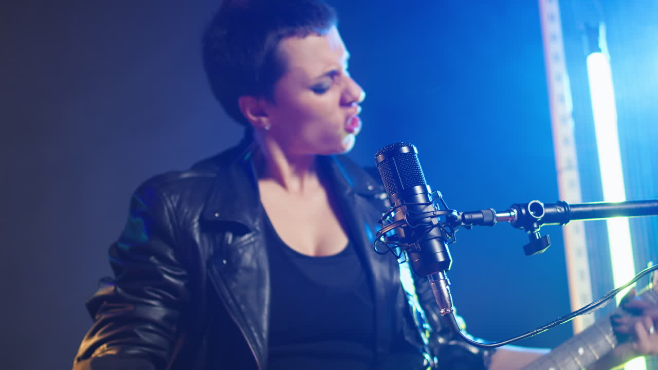 Female Musician Singing and Playing Guitar on Stage