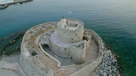 An-aerial-city-view-of-Rhodes-island-in-Greece-containing-clips-of-the-medieval-old-town,-the-old-lighthouse-at-the-port,-old-windmills,-beaches-and-amazing-sunset