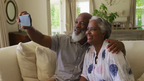 Afroamerikanisches-älteres-Paar-Lächelt,-Während-Es-Zu-Hause-Ein-Selfie-Vom-Smartphone-Macht