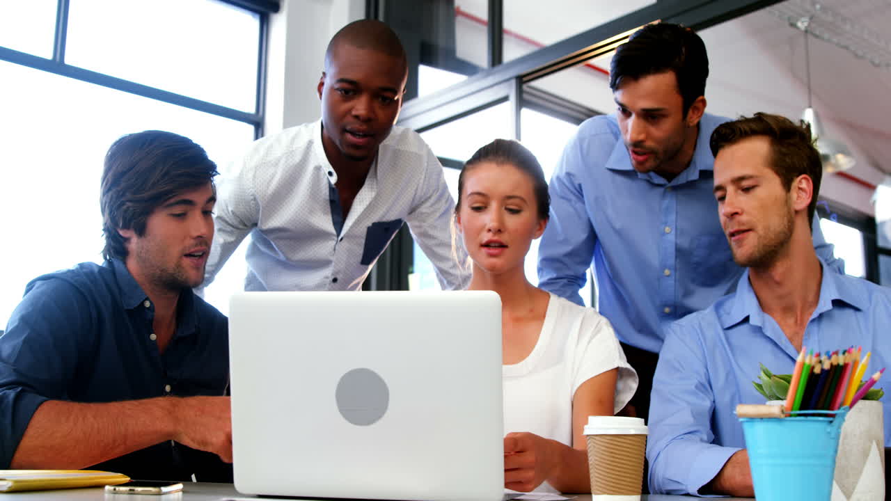 Business executives discussing over laptop and digital tablet