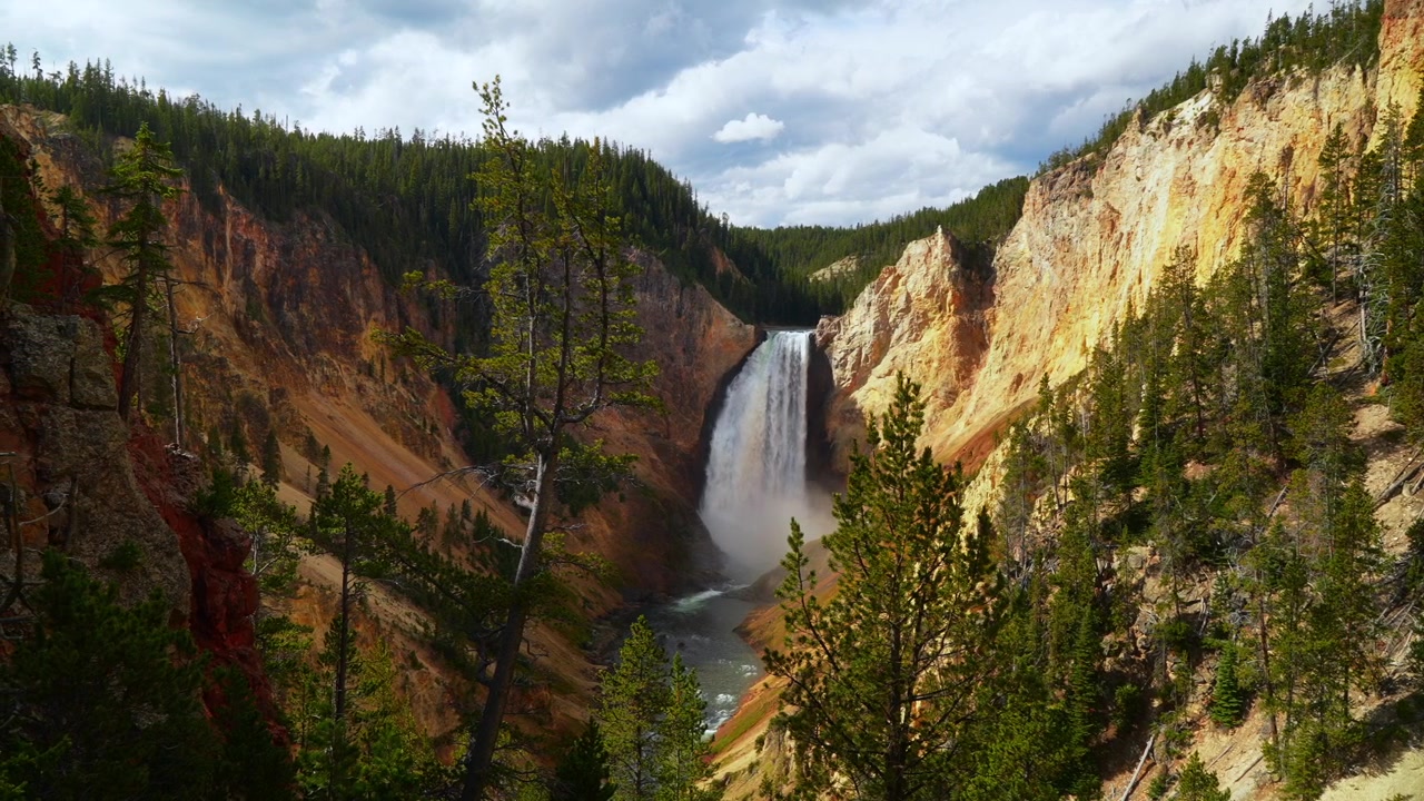 Pemandangan panorama Grand Canyon Yellowstone dari Titik Pandang Batu Merah dan Titik Inspirasi di Jalan Tepi Utara Taman Nasional Yellowstone, Wyoming. Menampilkan air terjun bertingkat Sungai Yellowstone, lanskap alam yang cerah di pagi hari dengan awan.