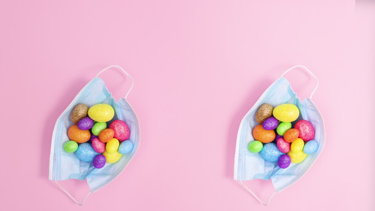 Duas máscaras faciais criativas com ovos de Páscoa em fundo rosa pastel. Stop motion
